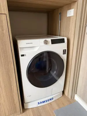 a washing machine in a cabinet in a room at 5 Min walk to BTS Onnut Duplex Loft At Sukhumvit in Amphoe Phra Khanong