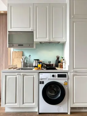 a kitchen with white cabinets and a washing machine at WalkToBTS>EMDistrict/CityViewPool&Gym/WiFi/Washer in Khlong Toei