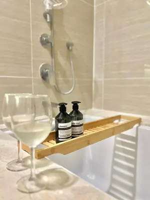 a bottle of wine and a glass on a shelf in a bathroom at WalkToBTS>EMDistrict/CityViewPool&Gym/WiFi/Washer in Khlong Toei