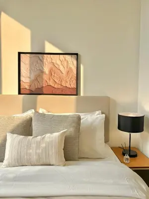 a bed with white pillows and a table with a lamp at WalkToBTS>EMDistrict/CityViewPool&Gym/WiFi/Washer in Khlong Toei