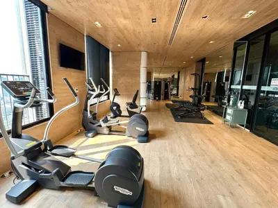a gym with treadmills and ellipticals in a room at WalkToBTS>EMDistrict/CityViewPool&Gym/WiFi/Washer in Khlong Toei