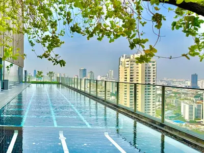 a swimming pool on the roof of a building with buildings at WalkToBTS>EMDistrict/CityViewPool&Gym/WiFi/Washer in Khlong Toei