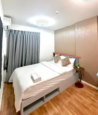 a bedroom with a white bed with a window at Lumpiniville Sukhumvit in Bangna