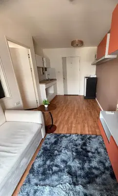 a living room with a white couch and a refrigerator at Lumpiniville Sukhumvit in Bangna