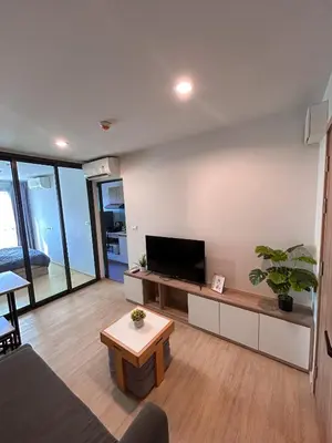 a living room with a couch and a tv at Luxury apartment near On Nut BTS station with swimming pool in Amphoe Phra Khanong
