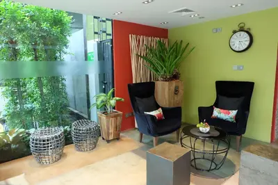 a room with two chairs and a clock on the wall at Aspira D'Andora Sukhumvit 16 - Asoke in Bangkok