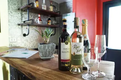 two bottles of wine sitting on a table with glasses at Aspira D'Andora Sukhumvit 16 - Asoke in Bangkok