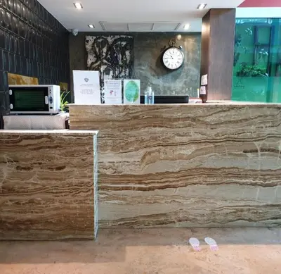 a counter in a restaurant with a clock on the wall at Aspira D'Andora Sukhumvit 16 - Asoke in Bangkok