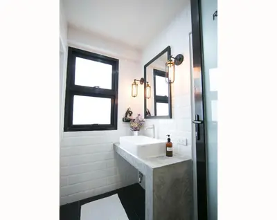 a bathroom with a sink and a mirror at Lamurr Sukhumvit 41 in Bangkok