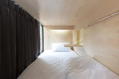 a bedroom with two beds and a window at Lamurr Sukhumvit 41 in Bangkok