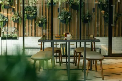 a table and chairs in a room with plants at NAP Hotel Bangkok in Bangkok