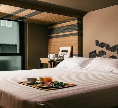 a tray of food sitting on top of a bed at NAP Hotel Bangkok in Bangkok