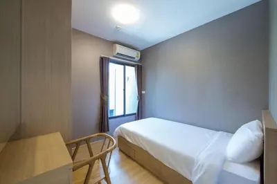 a small bedroom with a bed and a window at Like Sukhumvit 22 in Bangkok