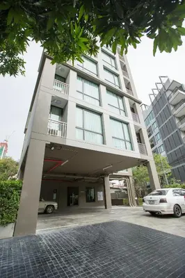 a white building with cars parked in front of it at Like Sukhumvit 22 in Bangkok