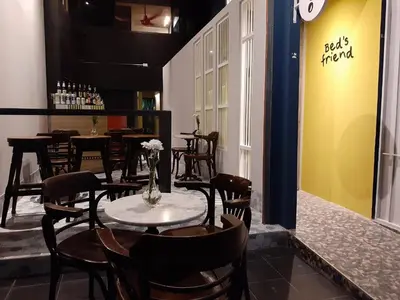 a restaurant with a table and chairs in a room at Bed's Friend in Bangkok