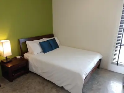 a bed with two blue pillows on it in a bedroom at Udee Bangkok Hostel in Bangkok