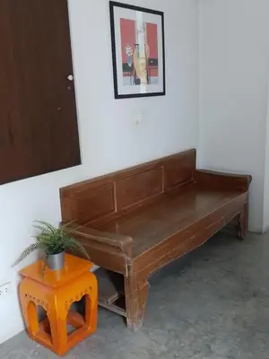 a wooden bench in a room with a potted plant at Udee Bangkok Hostel in Bangkok