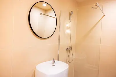 a bathroom with a shower and a sink and a mirror at Metro Pratunam Boutique Hotel in Pratunam