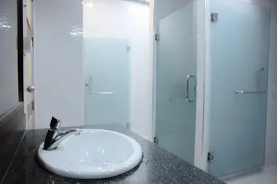 a white bathroom with a sink and a shower at Metro Pratunam Boutique Hotel in Pratunam