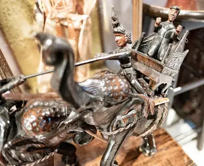 a metal figurine of a man riding a camel on a horse at Check-in My Hostel in Bangkok