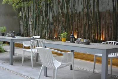 two tables and white chairs and a fence at Rezt Bangkok in Bangkok