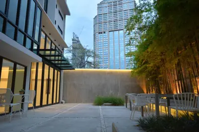 a patio with tables and chairs in a city at Rezt Bangkok in Bangkok