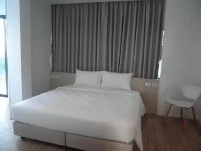 a white bed in a room with a window at Rezt Bangkok in Bangkok