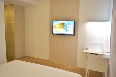a hotel room with a tv on the wall at Rezt Bangkok in Bangkok