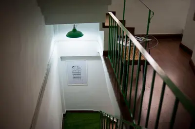 a stairway with a green light and a green rug at Victory Park Hostel in Bangkok