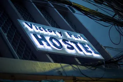a sign on a building that reads welcome to the hospital at Victory Park Hostel in Bangkok