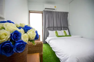 a bedroom with a bed and a basket of blue roses at Victory Park Hostel in Bangkok