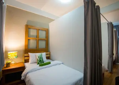 a bedroom with a white bed with a window at Victory Park Hostel in Bangkok