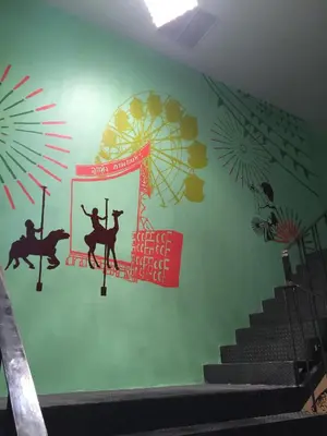 a room with a staircase with a green wall at Bed@Town Hostel in Bangkok