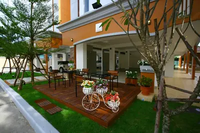 a wooden deck with a bike with flowers on it at At Home Phetkasem in Bangkok