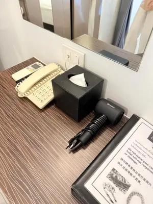 a desk with a pen and a phone on it at Cubic Pratunam in Bangkok