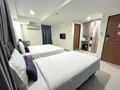 a hotel room with two beds and a television at Cubic Pratunam in Bangkok