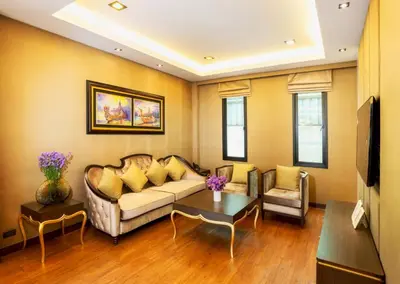 a living room with a couch and a table at Chiva Bangkok Hotel in Bangkok