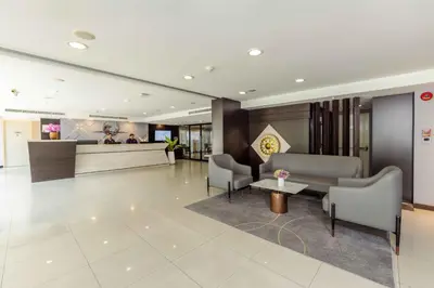 a lobby with a waiting area with chairs and a counter at Chiva Bangkok Hotel in Bangkok
