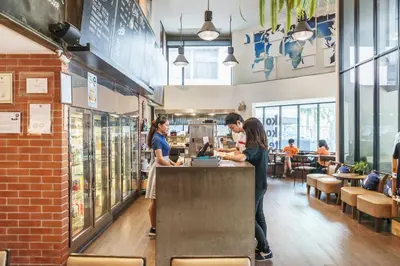 two women standing at a counter in a restaurant at Kokotel Bangkok Surawong in Bangkok