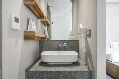 a bathroom with a white sink on a counter at Kokotel Bangkok Surawong in Bangkok
