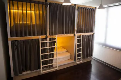 a room with a bed in a room with curtains at Movylodge in Bangkok