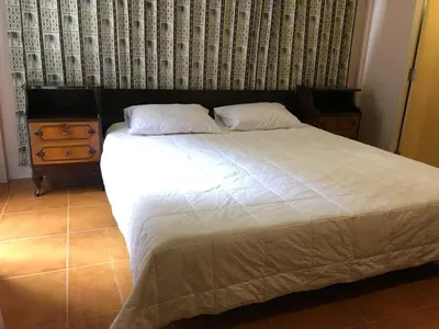a bedroom with a large bed and a dresser at The Grand Palace Hotel in Bangkok
