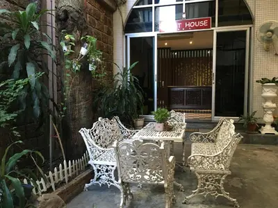two chairs and a table in front of a house at The Grand Palace Hotel in Bangkok
