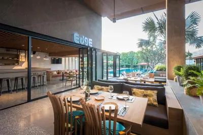 a restaurant with tables and chairs and a bar at The Silver Palm Wellness Resort in Bangkok