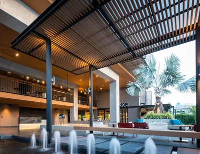 a lobby with chairs and tables in a building at The Silver Palm Wellness Resort in Bangkok