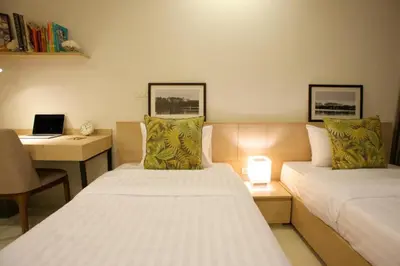a room with two beds and a desk with a laptop at The Silver Palm Wellness Resort in Bangkok