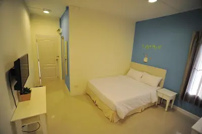 a small bedroom with a bed and a television at The Garden Living in Bangkok