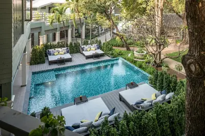 an overhead view of a swimming pool with lounge chairs and a resort at The Raweekanlaya Bangkok Wellness Cuisine Resort in Bangkok