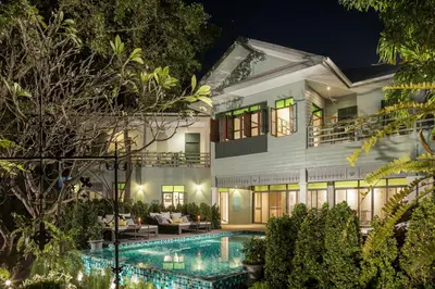 a villa with a swimming pool at night at The Raweekanlaya Bangkok Wellness Cuisine Resort in Bangkok