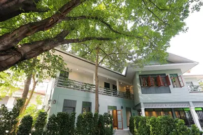 a large white building with trees in front of it at The Raweekanlaya Bangkok Wellness Cuisine Resort in Bangkok